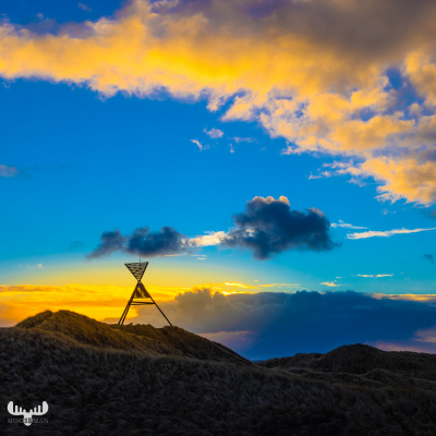 11056 - Husby Klit Båke seamark on dune  in rising sun with clouds