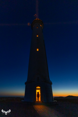 11226 - Nr.Lyngvig Fyr lighthouse at night with lights and person