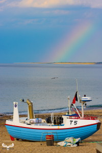 11621 - Rainbow over North sea with fishing boat on beach
