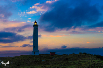12570 - Nr.Lyngvig Fyr lighthouse lighted with colorful sunset sky