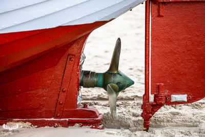 12586 - Ship propeller on red fishing boat on Løkken beach