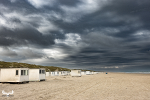 12610 - Løkken white beach houses and dark sky clouds