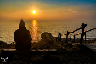 13653 - Person looking at sunset over North Sea at Bovbjerg Klint at stairways