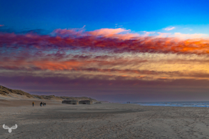 14364 - Colorful sunset at Søndervig North Sea beach with bunkers and people